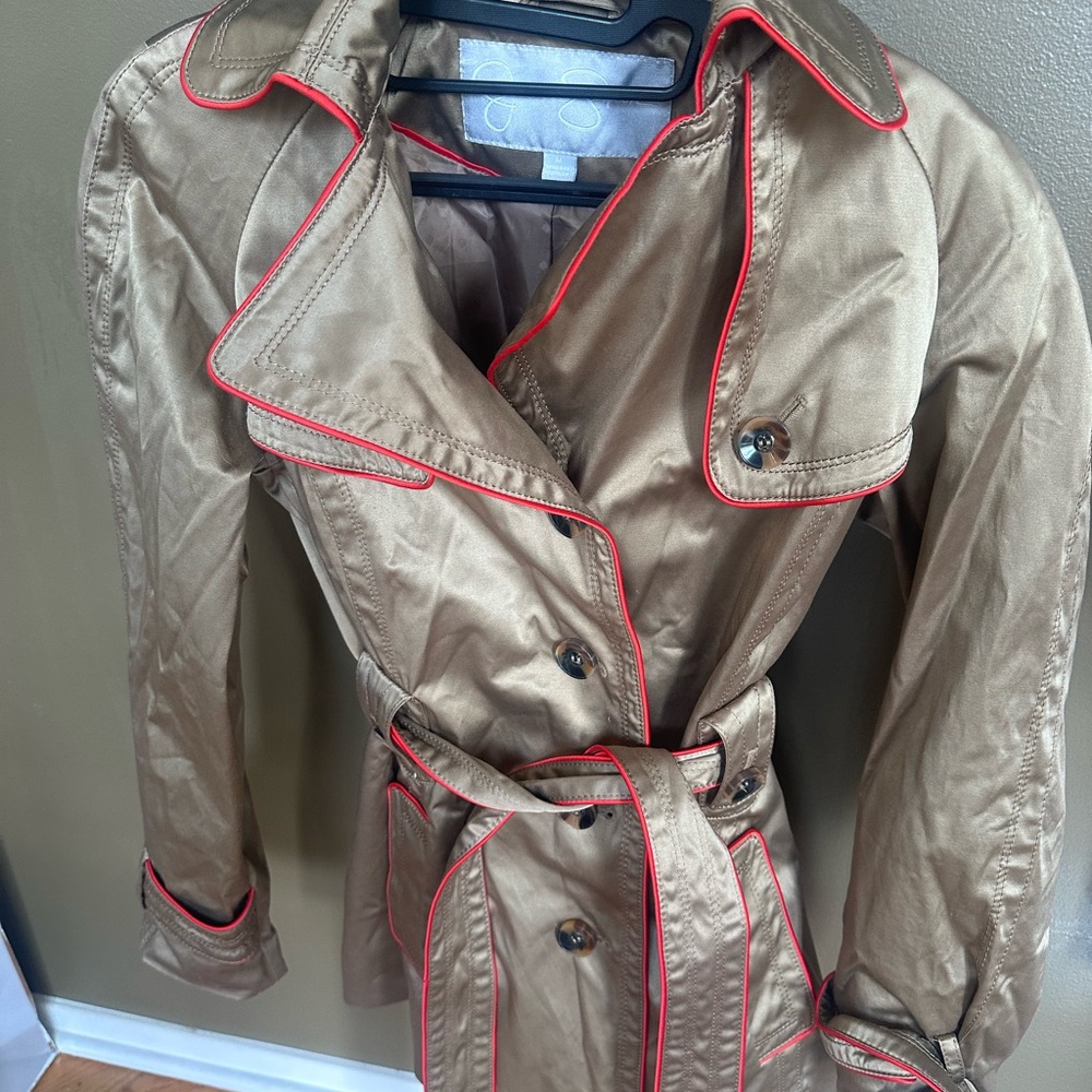 Modern trench coat with red piping. Satin finish.